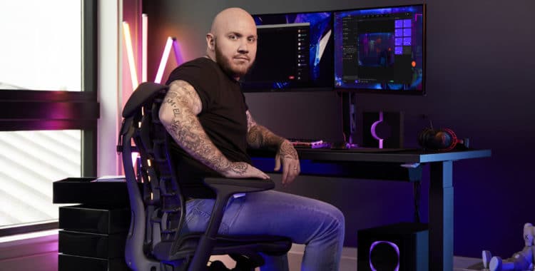 Tim the Tatman sitting in a Herman Miller chair in front of a gaming pc